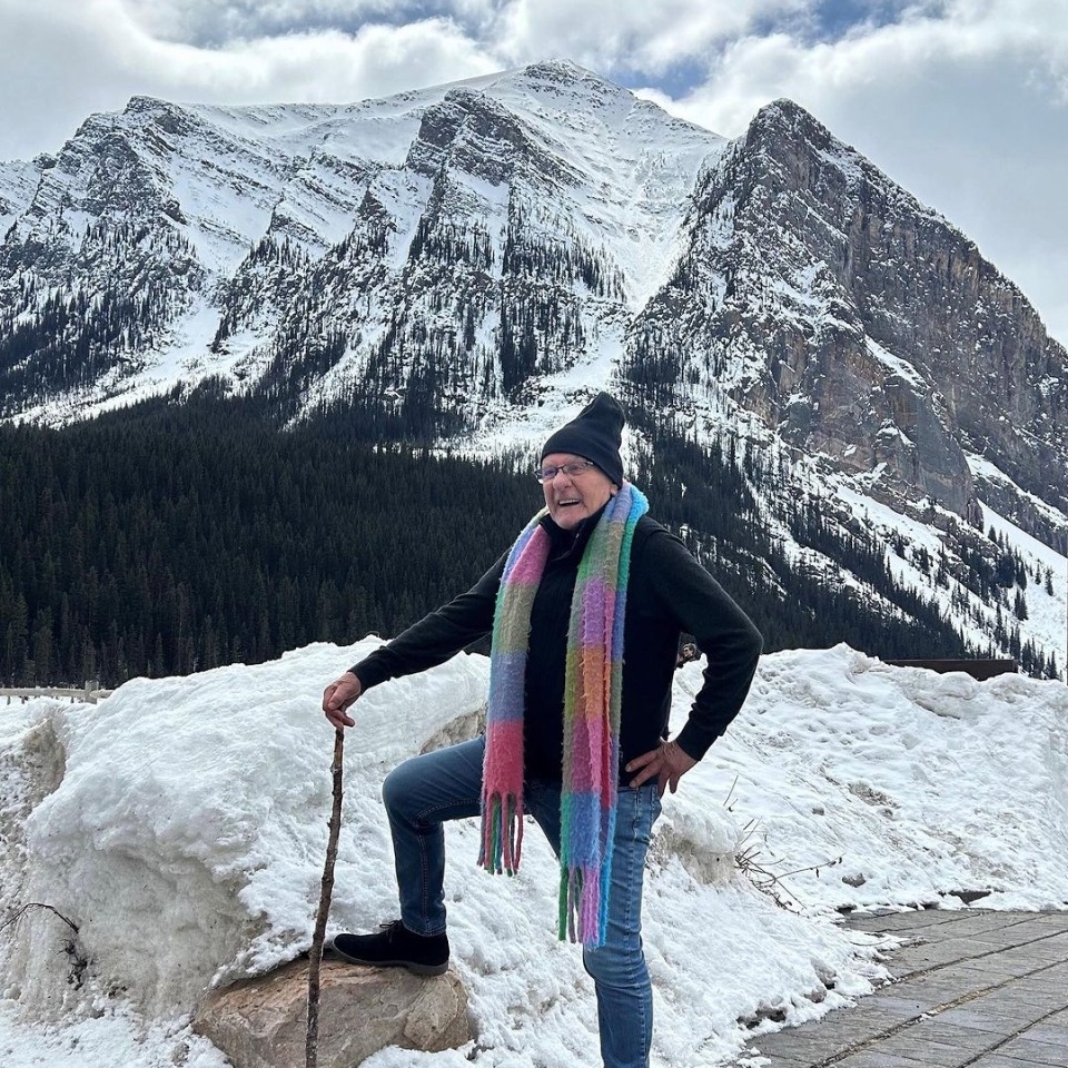 Man posing in front of a mountain.