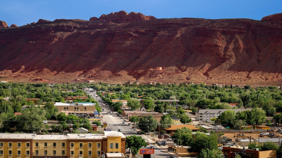 Photo of the city of Moab, Utah with Red Rock mountains in the background.