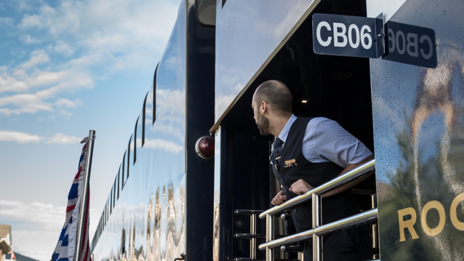 An onboard Host peers out from the GoldLeaf Service outdoor viewing platform.