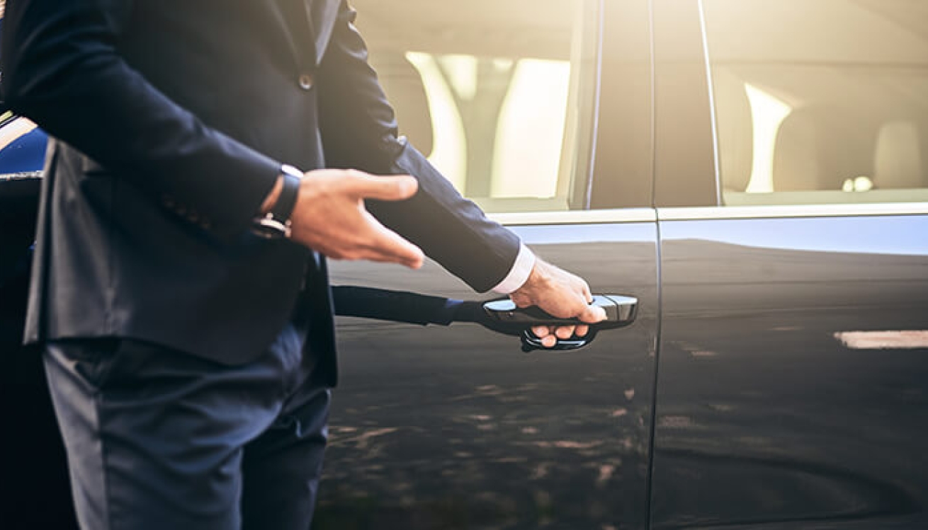 man opens door to black car