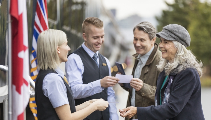guests show tickets to hosts before boarding the rocky mountaineer train